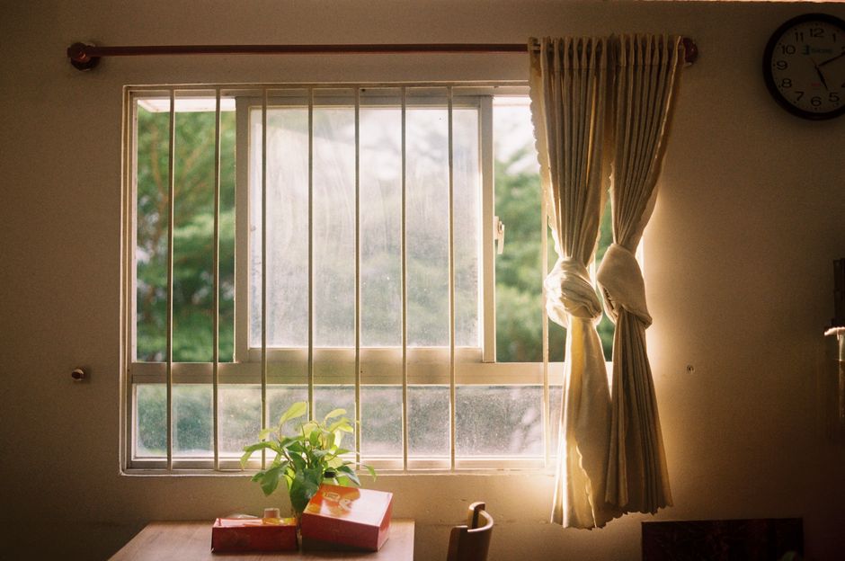 Sunlight streaming through a window onto a table with a plant in Ho Chi Minh City.