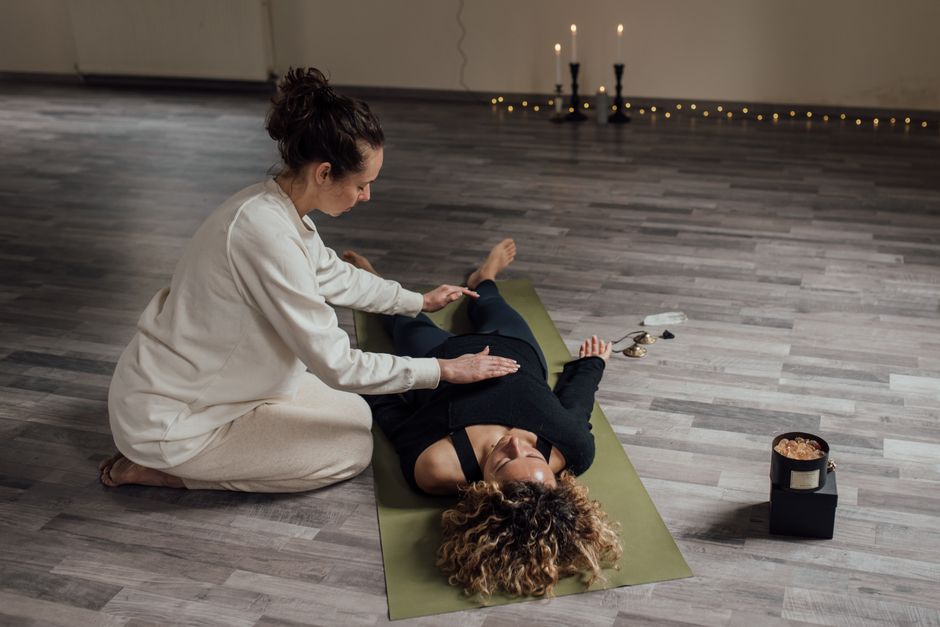 A serene indoor setting capturing a therapist using Reiki techniques on a client.