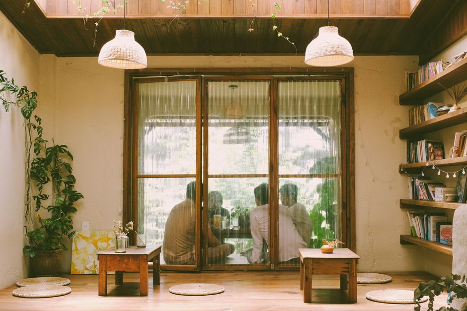 Gathering in a cozy room with natural light, wooden furniture, and decor.